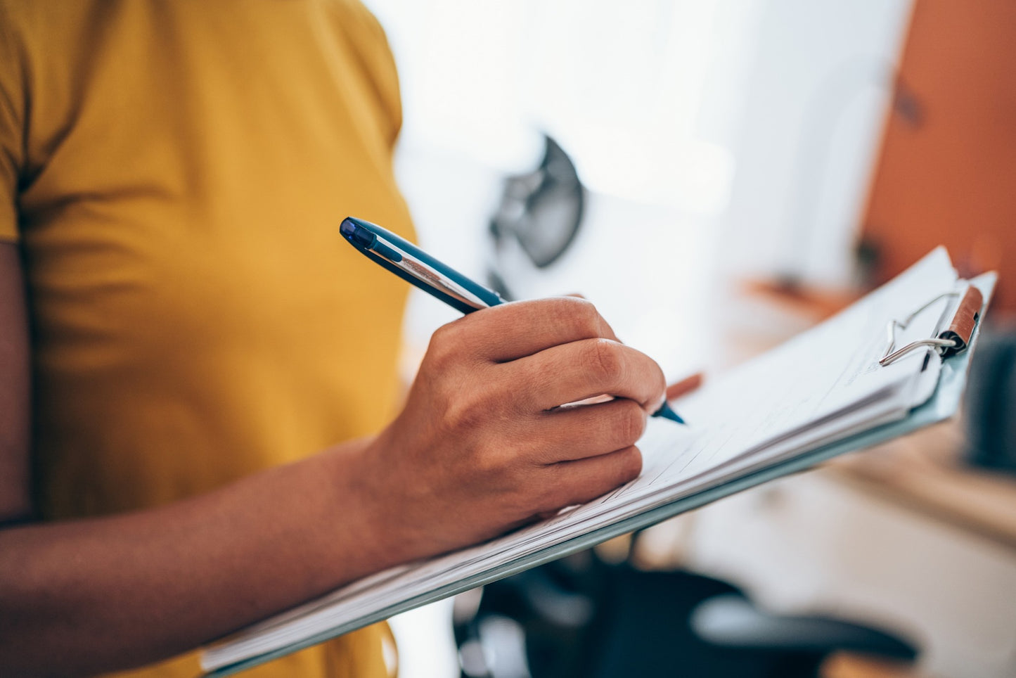 man writing things down on a clipboard